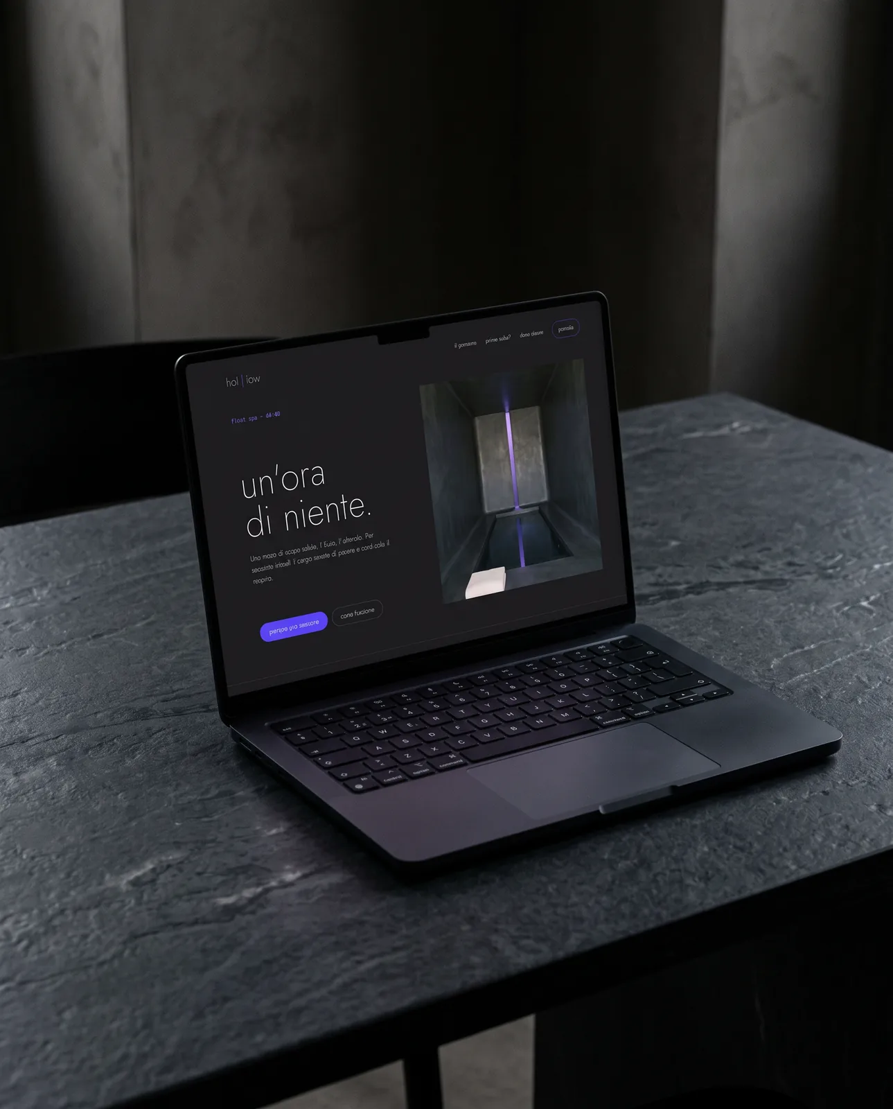 Un laptop con la home del sito di Hollow, in una stanza buia